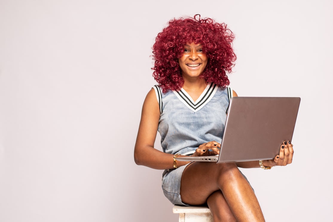 happy african lady using her laptop computer